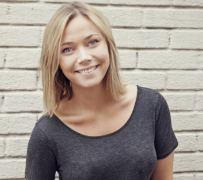 Screenshot of Karen Dolva in front of a white bricked wall.