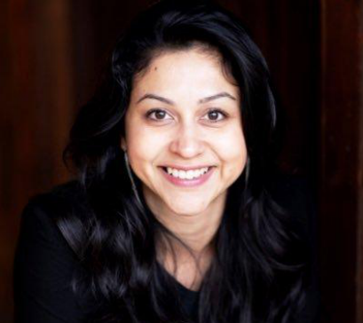 Photo of Neha Narkhede in front of a dark wall.