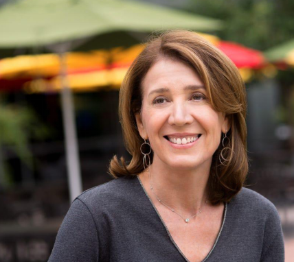 Photo of Ruth Porat looking at something in the distance smiling.